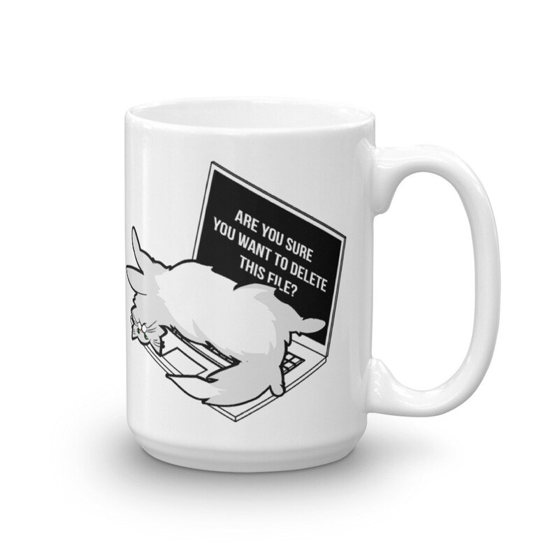 May include: White ceramic mug with a black and white illustration of a cat on a laptop. The text on the laptop screen reads "Are you sure you want to delete this file?"