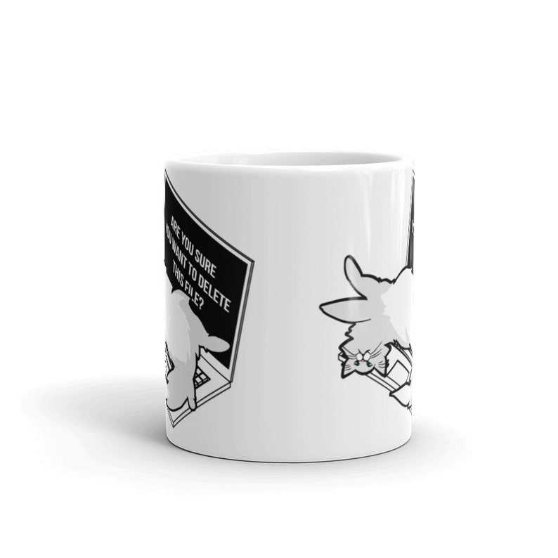 May include: White ceramic mug with a black and white illustration of a cat sitting at a computer with a pop-up message that says "Are you sure you want to delete this file?"