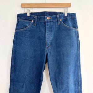 May include: A pair of dark blue denim jeans with a classic five-pocket style.