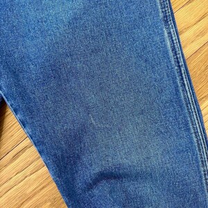 Puede incluir: Primer plano de tela vaquera azul con una textura sutil. La tela es lisa y parece suave.