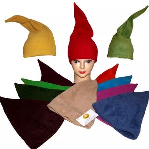 Puede incluir: Surtido de gorros de elfo en varios colores, incluyendo rojo, verde, amarillo, marrón, azul y morado. Los gorros están hechos de tela de felpa suave y tienen una punta puntiaguda.