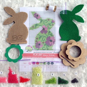 Pu&ograve; includere: Un kit per l'artigianato per realizzare un coniglio floreale. Il kit include una cornice in legno, feltro verde, perline e uno schema per la perlatura. Lo schema &egrave; stampato su un foglio bianco con il testo "FLK-267 (8cm x 12,5cm)".