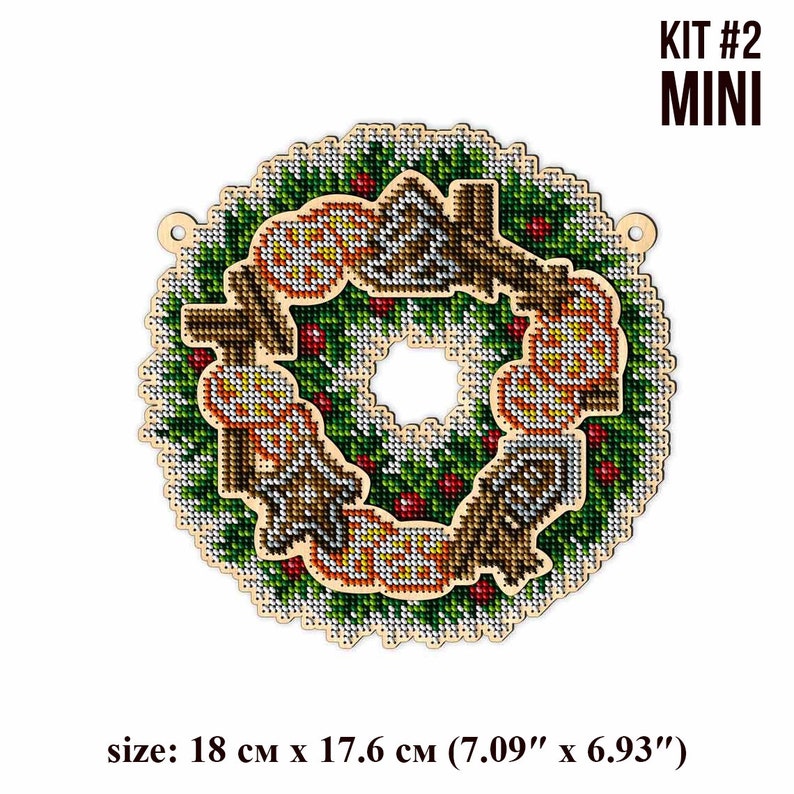 May include: A wooden Christmas wreath with a green and white design, featuring a red berry and a brown bird. The wreath is 7.09 inches by 6.93 inches and is labeled "KIT #2 MINI".