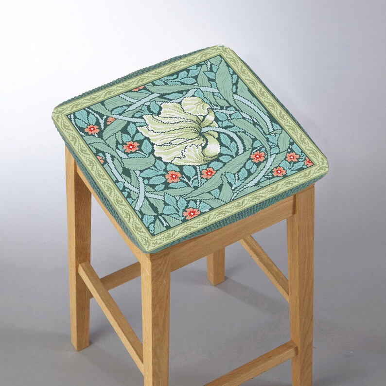 May include: A wooden bar stool with a green and white floral patterned cushion. The cushion has a green border with a light green and orange trim.