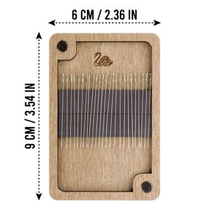 May include: A wooden needle storage box with a magnetic closure. The box is 6 inches wide and 9 inches tall. The box has a swan logo on the front and is filled with needles.