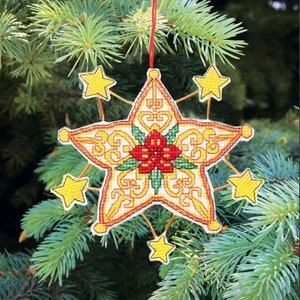 May include: A yellow star-shaped Christmas ornament with a red poinsettia in the center. The ornament has a gold and white pattern and is hanging from a red string.