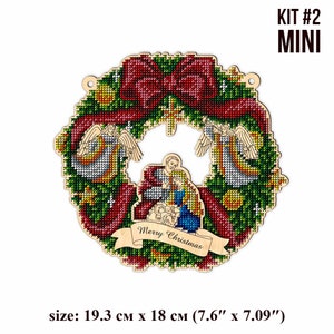May include: A wooden Christmas wreath with a red bow, two angels, and a nativity scene in the center. The wreath is decorated with green pine needles, red berries, and gold stars. The text "Merry Christmas" is written on a banner below the nativity scene. The wreath is 7.6 inches by 7.09 inches.
