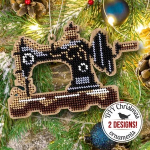 May include: A wooden Christmas ornament shaped like a vintage sewing machine, decorated with black, white, and gold beads. The ornament has a brown wooden base and a gold string for hanging. The ornament is labeled "DIY Christmas 2 DESIGNS! ornaments".