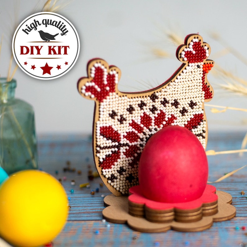 Puede incluir: Kit de bricolaje para un soporte de huevos de pollo con cuentas. El kit incluye una base de madera, cuentas e instrucciones. El producto terminado es una gallina encantadora y colorida con un huevo rojo en su nido.