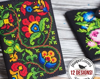 Op de afbeelding: Zwarte leren paspoorthoes met een kleurrijk borduurwerk van bloemen. De hoes is versierd met rode, gele, groene en blauwe bloemen. De tekst "passport covers 12 DESIGNS! DIY kits" is gedrukt op een witte cirkel.