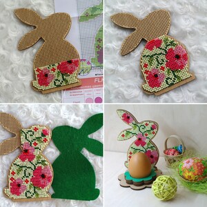 Pu&ograve; includere: Un porta uova di Pasqua in legno a forma di coniglio con un motivo floreale. Il coniglio tiene un uovo tra le zampe. Il coniglio &egrave; dipinto in tonalit&agrave; di marrone, rosa e verde. Il porta uova &egrave; su una base in legno.