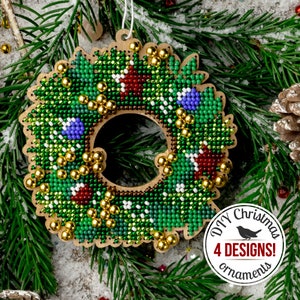 Può includere: Un ornamento natalizio in legno a forma di ghirlanda, con un design di perline verdi, impreziosito da perline rosse, blu e dorate. L'ornamento è circondato da rami di sempreverdi e presenta il testo "DIY Christmas 4 DESIGNS! ornaments".
