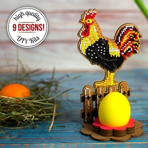 Pu&ograve; includere: Una statuetta di gallo in legno con un design a perline gialle, nere e rosse, in piedi su una recinzione di legno con un uovo giallo in un vaso di fiori rosso. Il testo "high quality 9 DESIGNS! DIY Kits" &egrave; su un cerchio rosso.