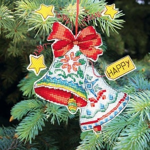 May include: Two red and white bells with a red bow and a yellow tag that says "HAPPY" hanging on a green Christmas tree.