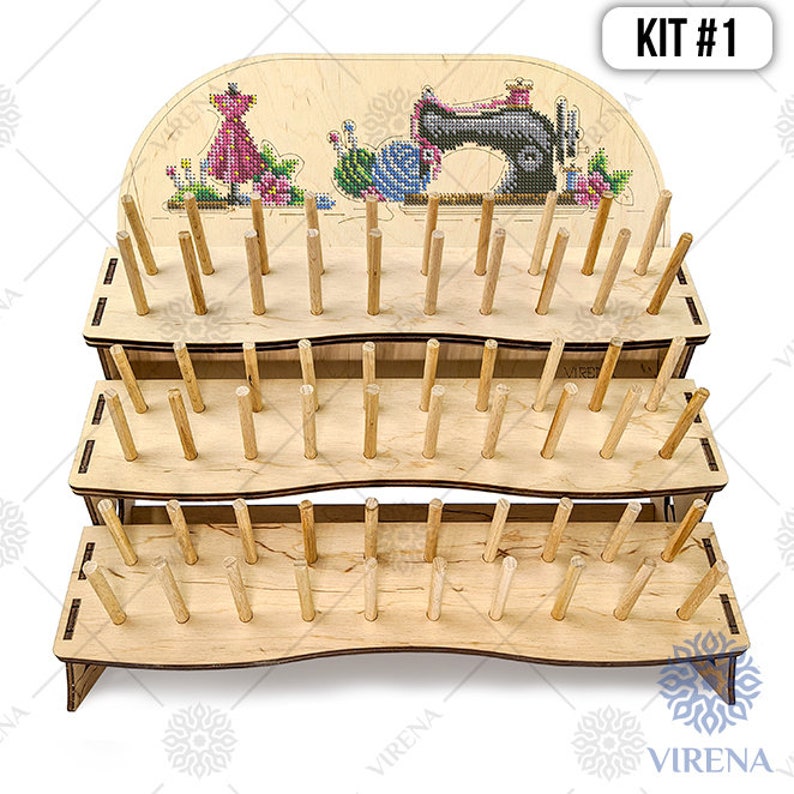 May include: A three-tier wooden thread stand with a sewing machine and a dress cross-stitch design on the top. The stand has 36 dowels for holding threads. KIT #1