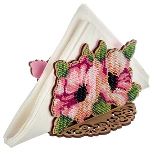 May include: A wooden napkin holder with a floral design. The holder is decorated with pink and green beads, creating a floral pattern. The holder is designed to hold a napkin in a triangular shape.
