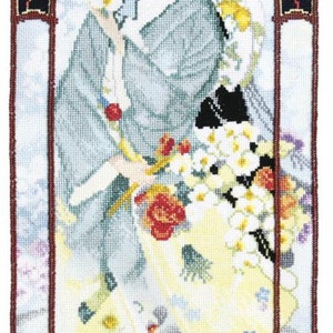 Op de afbeelding: Een ingelijst borduurwerk met kruissteek, waarop een vrouw in een blauwe en witte kimono te zien is die een boeket bloemen vasthoudt. Het borduurwerk is omgeven door een decoratieve rand met bloemmotieven.