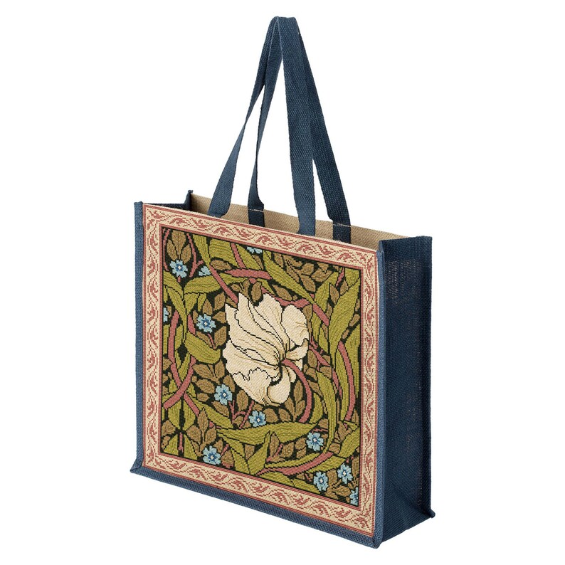 May include: A blue and beige tote bag with a floral design featuring a white flower and green leaves. The bag has a woven texture and two blue handles.