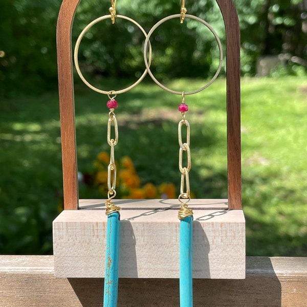 Gorgeous turquoise colored howlite gemstone spear drops paired with little garnets. With brass and gold accents. 14 goldfill hooks.