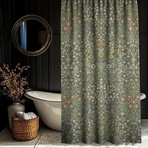 May include: A patterned shower curtain featuring a floral design in green, pink, yellow, and white. The curtain is in a bathroom with a white bathtub, a round mirror, and a woven basket.