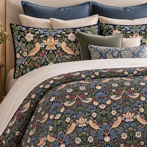 May include: A bedding set featuring a dark blue background with a repeating pattern of light brown birds, red strawberries, and various flowers in shades of blue, green, and white. The set includes a duvet cover and multiple matching pillows.