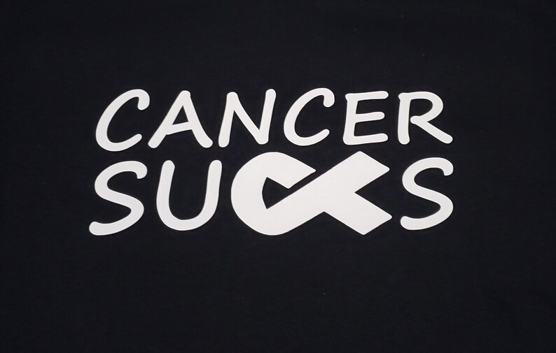 May include: Black background with the words "CANCER SUCKS" in white, stylized lettering. A white awareness ribbon replaces the "U" in "SUCKS". The image is a simple, bold statement.