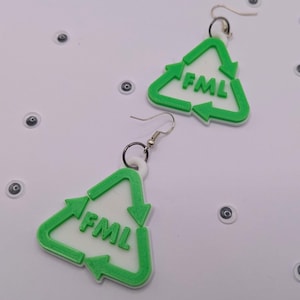 May include: A pair of green and white triangle shaped earrings with the acronym "FML" printed on them.