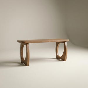 May include: A wooden bench with a natural finish. The bench has a rectangular seat and two curved, open-circle supports. The bench is approximately 48 inches long and 14 inches wide.