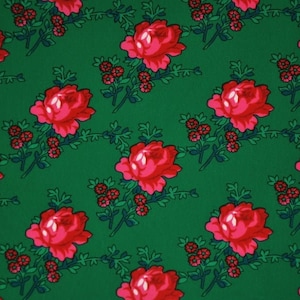 May include: A green fabric with a repeating pattern of red roses and small green leaves.
