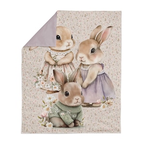Pode incluir: Tr&ecirc;s coelhos de aquarela com detalhes florais sobre um fundo marrom claro com um padr&atilde;o floral rosa claro. Os coelhos usam vestidos e um su&eacute;ter.