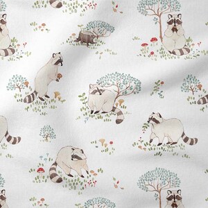 May include: A white fabric with a repeating pattern of raccoons, trees, mushrooms, and berries. The raccoons are depicted in a watercolor style and are holding various items, such as berries and mushrooms.
