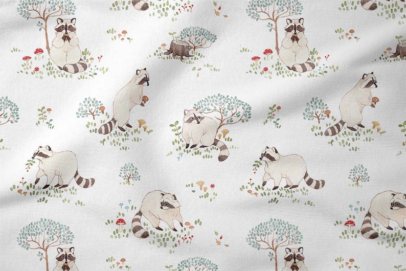 May include: A white fabric with a repeating pattern of raccoons, trees, mushrooms, and berries. The raccoons are depicted in a watercolor style and are holding various items, such as berries and mushrooms.
