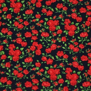 Può includere: Un tessuto blu scuro con un motivo ripetitivo di rose rosse. Le rose sono piccole e hanno un design semplice.