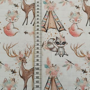 May include: White fabric with a repeating pattern of woodland animals, including foxes, deer, and raccoons. The animals are wearing floral crowns and there are teepees and arrows in the pattern.