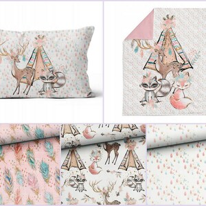 May include: A pink and white baby bedding set with a woodland theme. The set includes a pillow, a blanket, and three fabric swatches. The fabric swatches feature a variety of patterns, including feathers, arrows, and a teepee with animals.