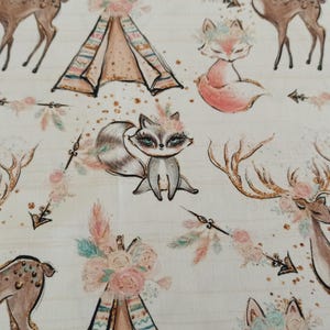 May include: A white fabric with a repeating pattern of woodland animals, including foxes, raccoons, and deer. The animals are surrounded by floral designs, arrows, and teepees. The fabric has a subtle glitter effect.