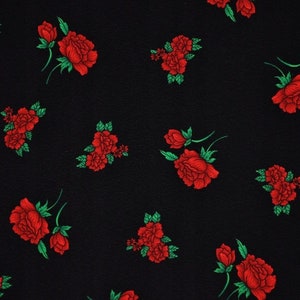Könnte beinhalten: Schwarzer Stoff mit einem sich wiederholenden Muster aus roten Rosen mit grünen Blättern.