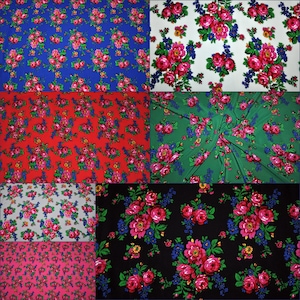 Op de afbeelding: Een verzameling van acht stofstalen met een bloemenpatroon met roze rozen, groene bladeren en blauwe en gele accenten. De stoffen zijn in verschillende kleuren, waaronder blauw, rood, groen, zwart, grijs en roze.