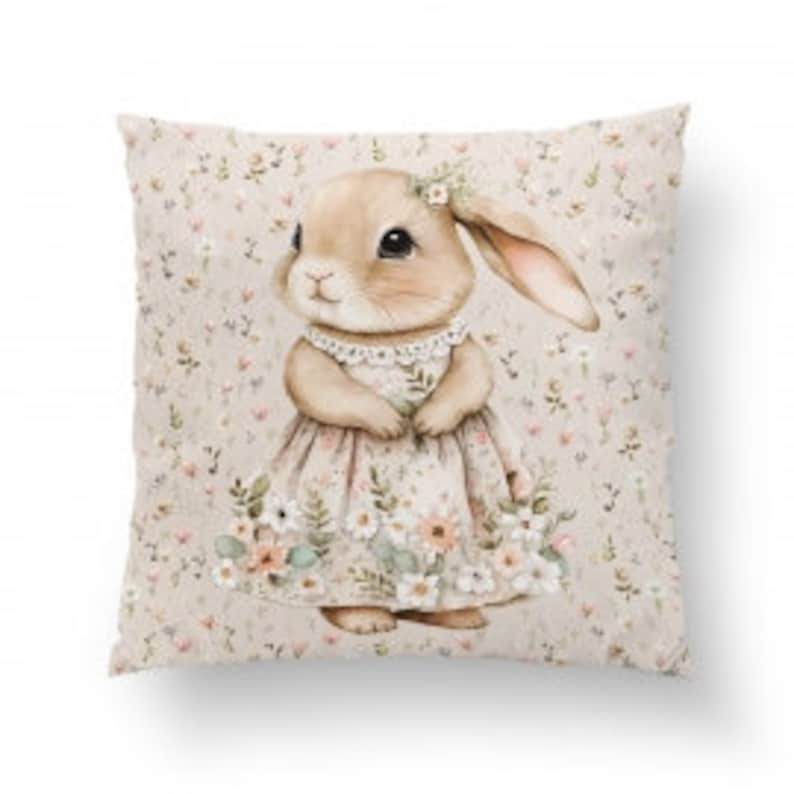 Pode incluir: Uma almofada bege com um padr&atilde;o floral que apresenta um coelho marrom vestindo um vestido rosa e uma faixa de cabe&ccedil;a floral.