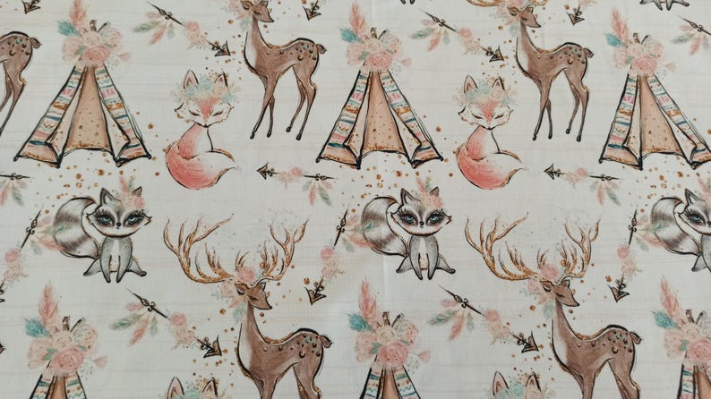 May include: A white fabric with a repeating pattern of woodland animals, including deer, foxes, and raccoons. The animals are illustrated in a whimsical style with floral accents. The pattern also includes teepees and arrows.