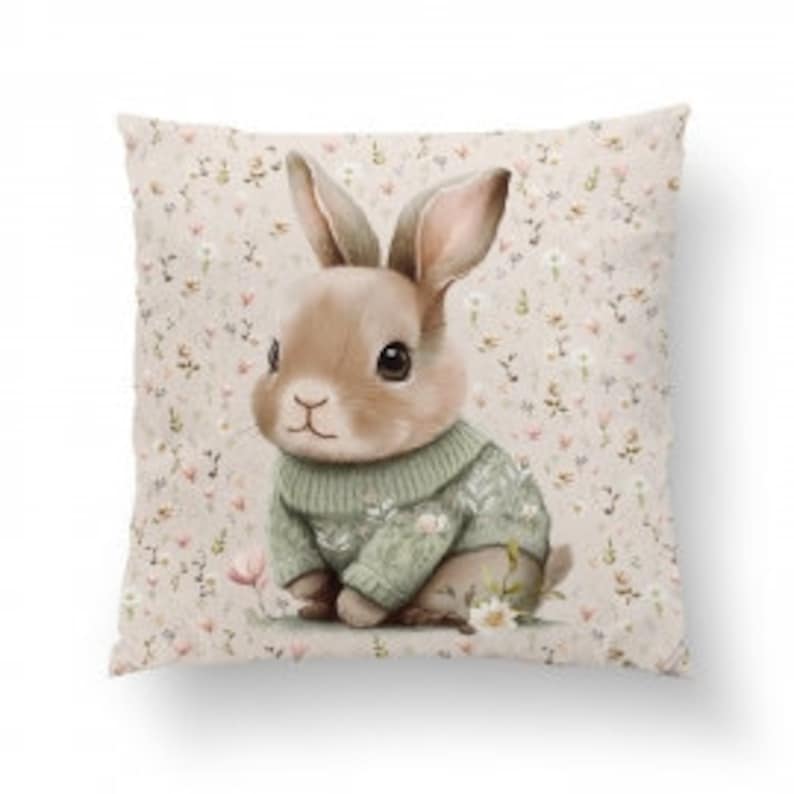 Pode incluir: Um coelho marrom vestindo um su&eacute;ter verde com um padr&atilde;o floral branco est&aacute; sentado em um fundo bege com um padr&atilde;o floral branco.