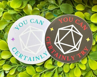 May include: Two round stickers with a white background and black outline. The stickers feature a white and gray dice with the text "You Can Certainly Try" in black and red lettering.