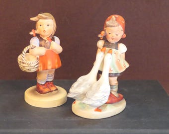 Figuras de Goebel Hummel: "La pastora de gansos" y "El pequeño comprador"