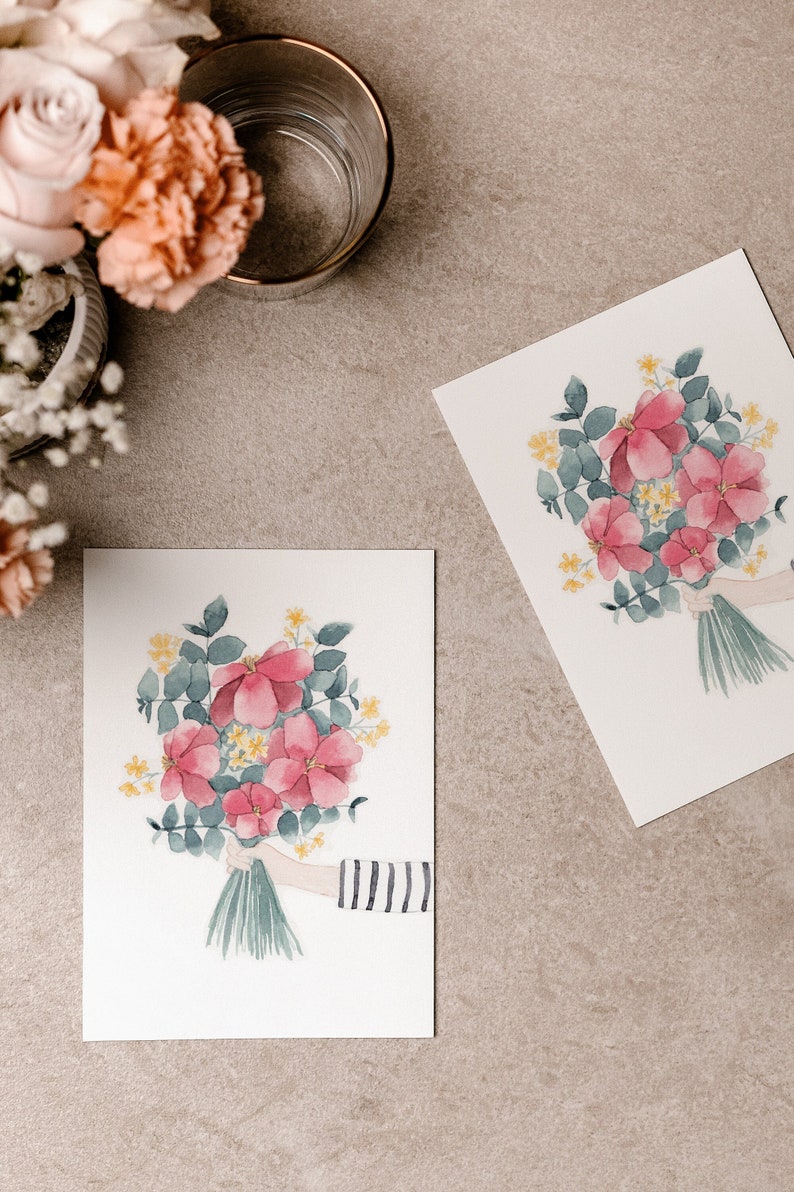 Postkarte aus dickem Naturpapier mit natürlicher Haptik.Bedruckt mit handgemaltem Aquarell Blumenstrauß aus pinkroten Pfingstrosen,kleinen gelben Blümchen,Eucalyptus.Der Strauß wird von einer Hand ins Bild gehalten.Der Arm trägt ein Ringelshirt.