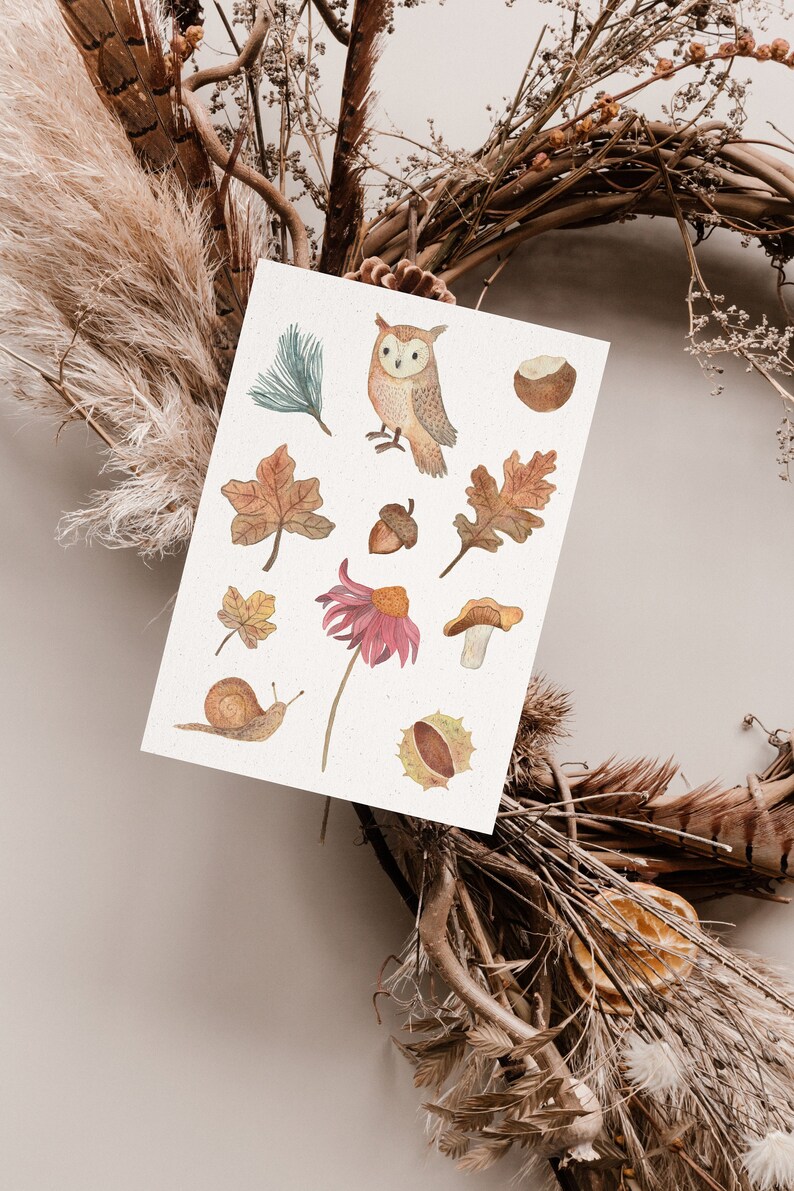 Herbstliche Postkarte mithandgemalten Aquarellmotiven: einer Eule, Kastanien, Eicheln, Herbstlaub, einem Pilz, einer Schnecke und einem Sonnenhut. Alles in natürlichen herbstlichen gedeckten Farben wie Brauntöne, Senfgelb, Dunkelrot und Beige.