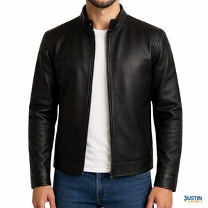 Könnte beinhalten: Schwarze Lederjacke mit Stehkragen und durchgehendem Reißverschluss. Die Jacke hat lange Ärmel und eine taillierte Passform. Das Model trägt ein weißes T-Shirt und blaue Jeans. Klassischer Jackenstil.