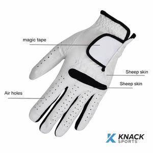 Puede incluir: Guante de golf blanco con detalles negros, incluyendo orificios de ventilación. Hecho de piel de oveja, tiene un cierre de velcro. El logotipo de Knack Sports es visible en la esquina inferior derecha.