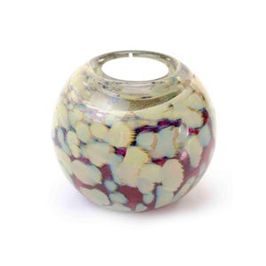 Op de afbeelding: Een ronde, decoratieve glazen kandelaar. De kandelaar is lichtgeel met blauwe en paarse accenten. Het glas heeft een gespikkeld patroon. De bovenkant heeft een cirkelvormige opening voor een kaars.