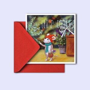 May include: A greeting card with a red envelope. The card features a watercolor illustration of a mouse wearing a hat and scarf, holding a basket. The text "LET'S COOK!" is written on the card.