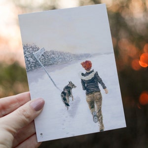 Op de afbeelding: Een schilderij van een persoon en een hond die door een besneeuwd landschap lopen. De persoon draagt een bruin jack en een witte sjaal. De hond is een bruin-witte mix. De achtergrond is een besneeuwd bos.